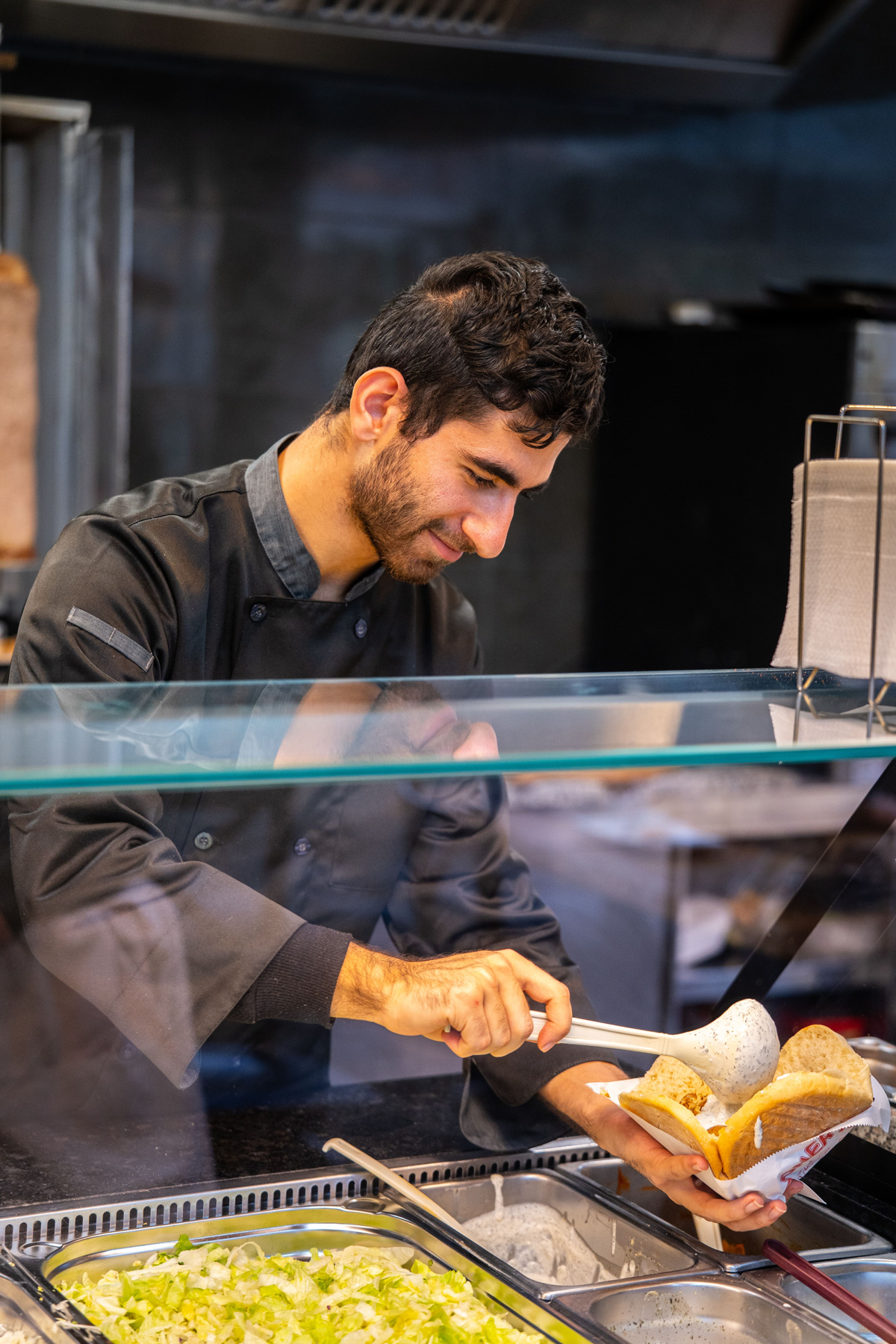 Sauce an der Theke wird frisch auf den Döner gegeben